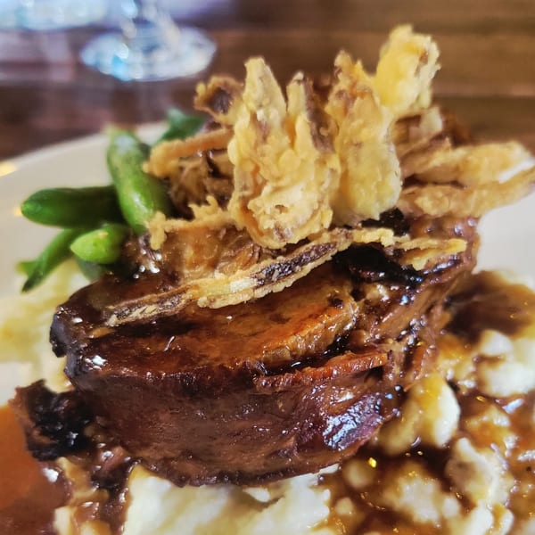 Braised short ribs with gravy, mashed potatoes, green beans, and crispy fried onions.